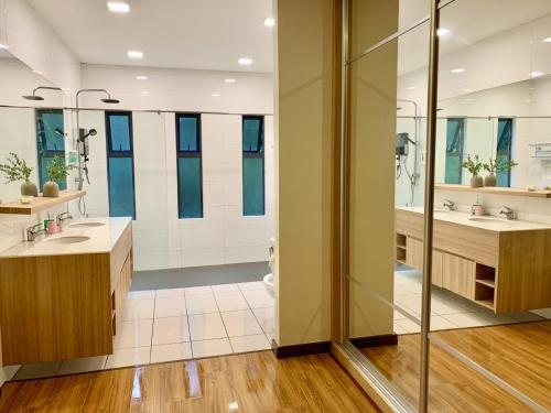 a bathroom with two sinks and two mirrors at Deco Home Mesilau Golf Bungalow Kundasang in Kundasang