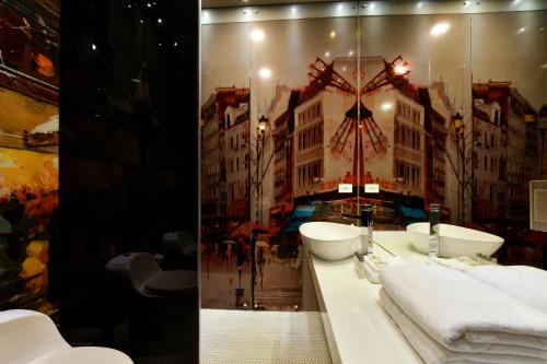 a bathroom with white sinks and a large mirror at Europa Suites Medellin in Medellín