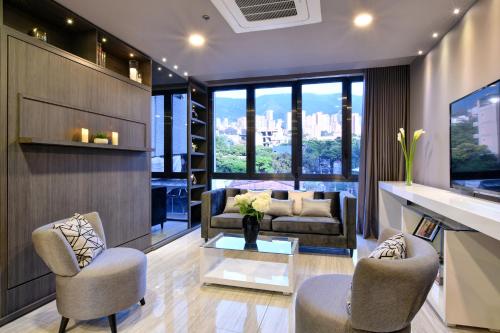 a living room with a couch and chairs and a table at Europa Suites Medellin in Medellín