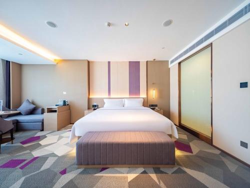 a bedroom with a large bed and a couch at Lavande Hotel Dongguan Dongkeng in Dongguan