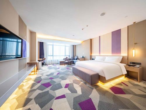 a hotel room with a bed and a tv at Lavande Hotel Dongguan Dongkeng in Dongguan