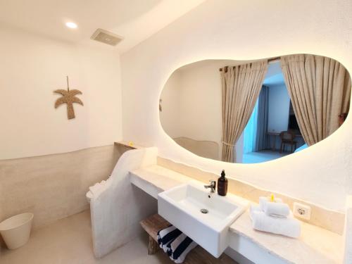 a bathroom with a sink and a mirror at Villa Vinodayan Uluwatu by LODGELINK BALI in Uluwatu