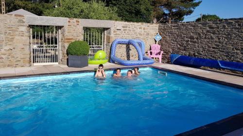 un groupe de personnes nageant dans une piscine dans l'établissement Le petit havre, à Pordic