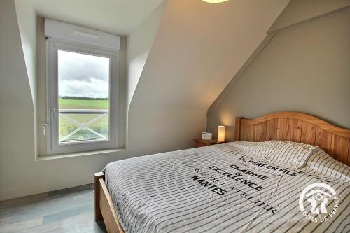 a bedroom with a large bed with a window at Le petit havre in Pordic