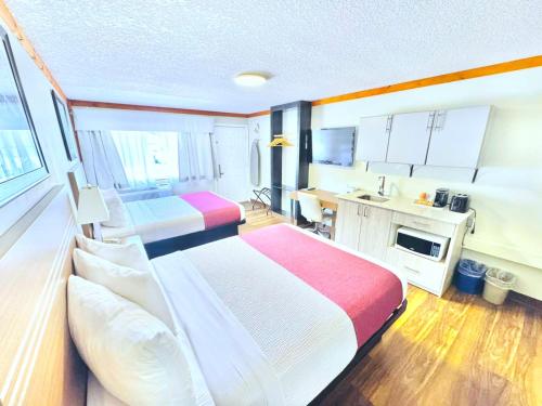a hotel room with two beds and a kitchen at Travelodge by Wyndham Golden Sportsman Lodge in Golden