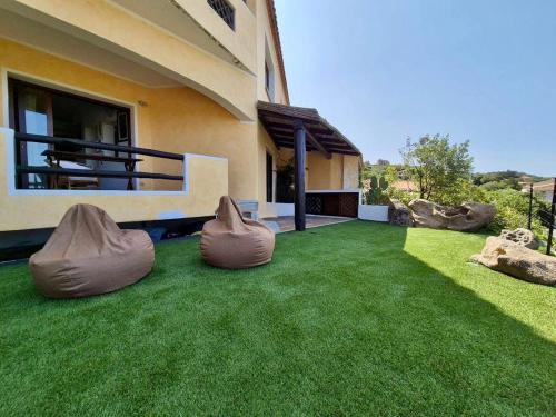 a house with a yard with green grass at Casa Alessandra, Apartment in Porto Cervo in Porto Cervo
