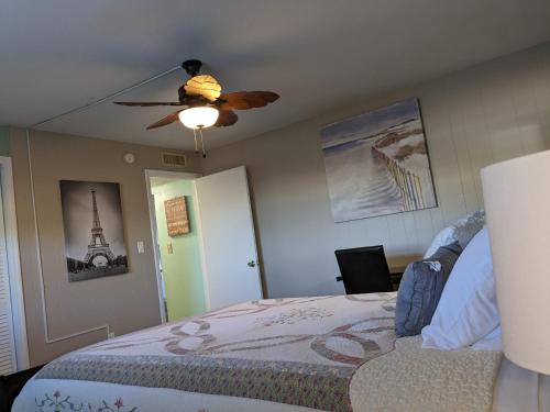 a bedroom with a bed and a ceiling fan at Ocean Front by Cocoa Beach Pier in Cocoa Beach