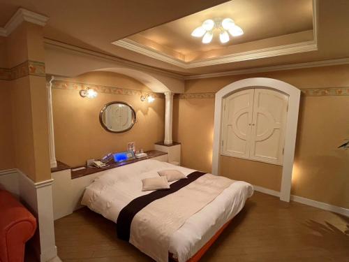 a bedroom with a large white bed with a mirror at ホテル湯島御苑水戸店 in Mito