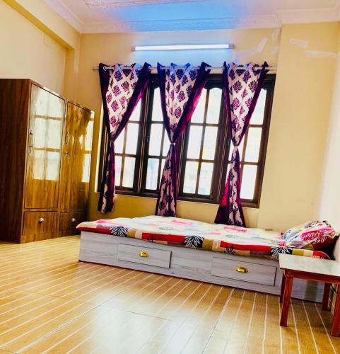 a bedroom with a bed in a room with windows at Madame Flexstay Girls Hostel in Kathmandu