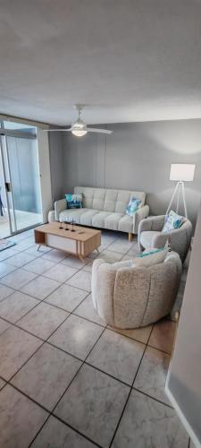 a living room with two couches and a coffee table at LaMouette 8 Manaba Beach Uvongo in Margate