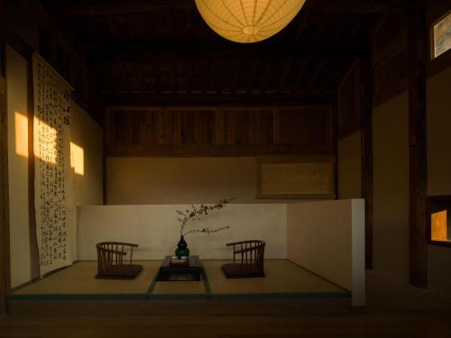 a room with two chairs and a table with a vase at Yunzhu Healing Boutique B&B in Chongqing