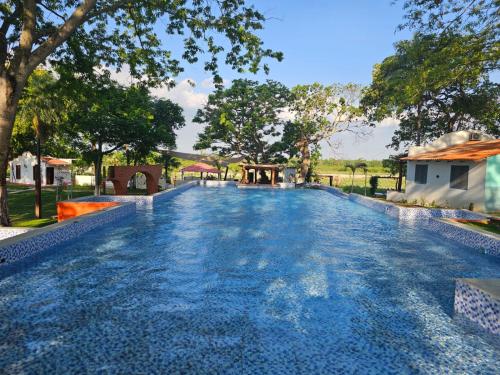una piscina en un complejo turístico con agua azul en La Riviera del Urubo Eco-Resort, en Huarapucú