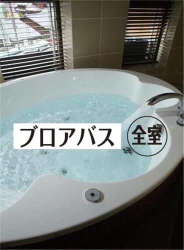 a bath tub with a sign on the side of it at Hotel Mio City (Adult Only) in Yokkaichi