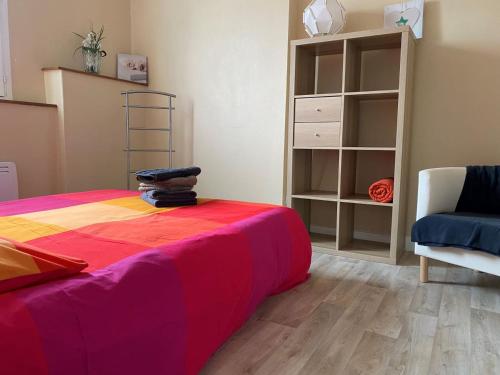 - une chambre avec un lit et une couverture colorée dans l'établissement Vichy Coeur de Ville, à Vichy