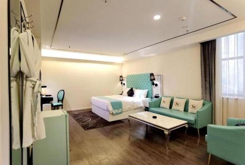 a hotel room with a bed and a couch at Xana Lite Korla Shihua Avenue Longquehe in Korla
