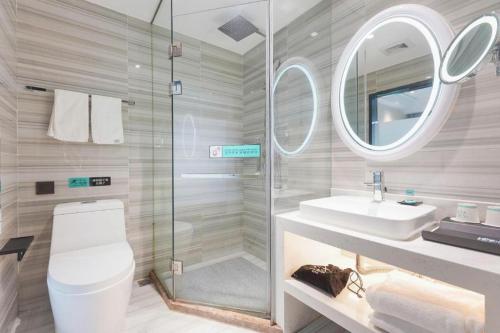 a bathroom with a toilet and a sink and a mirror at Xana Lite Beijing Sidaokou Dazhong Temple Metro Station Branch in Beijing