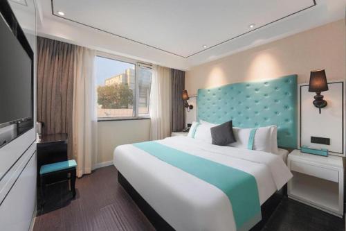 a bedroom with a large bed and a large window at Xana Lite Beijing Sidaokou Dazhong Temple Metro Station Branch in Beijing
