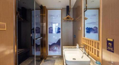 a bathroom with a shower and a tub and a sink at East Queen Hotel (Xi'an Beimen Metro Station) in Xi'an