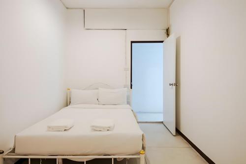 a white bed in a white room with a door at XX GO INN Asiatique Bangkok - โกอินน์ เอเชียทีค เจริญกรุง in Bangkok