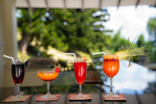 a group of four cocktails sitting on a table at Hotel Topaz in Kandy