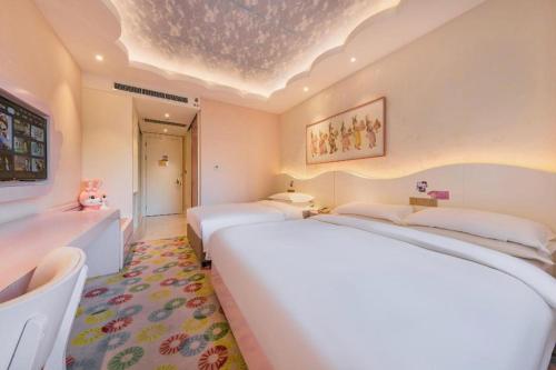 a bedroom with two beds in a room with a ceiling at Deefly Yinrun Town Hotel in Deqing