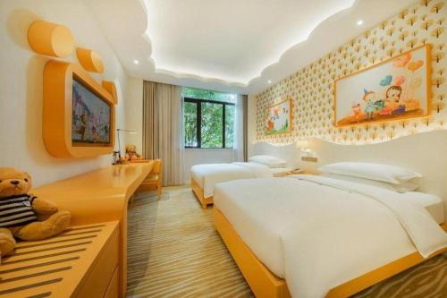 a bedroom with two beds and a teddy bear in it at Deefly Yinrun Town Hotel in Deqing