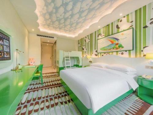 a bedroom with a large white bed and green walls at Deefly Yinrun Town Hotel in Deqing