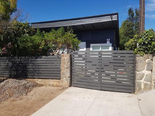 a fence with a gate in front of a house at Casa Papudo in Papudo