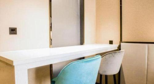 a room with two chairs and a counter with a blue chair at Xana Lite Hotelle Yan'an Baota Mountain in Yan'an