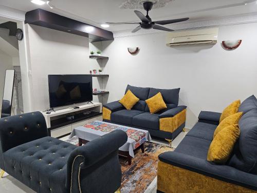 a living room with blue couches and a tv at HomeS7 Shah Alam in Shah Alam