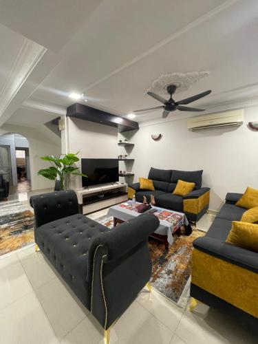 a living room with a couch and a tv at HomeS7 Shah Alam in Shah Alam