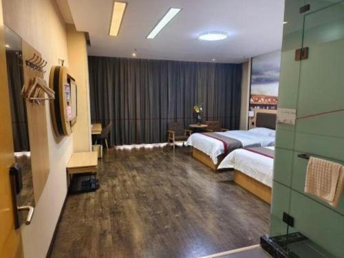 a hotel room with two beds and a desk at Thank Inn Plus Hotel Guangdong Yunfu Luoding City Municipal in Yunfu