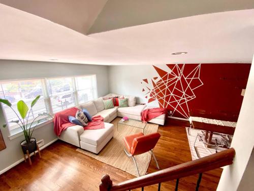a person sitting on a couch in a living room at Easy PATH&Bus access- NYC| designer home + Deck. in Jersey City