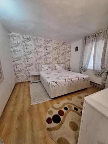 a bedroom with a bed and a wooden floor at Casa Delia in Călimăneşti