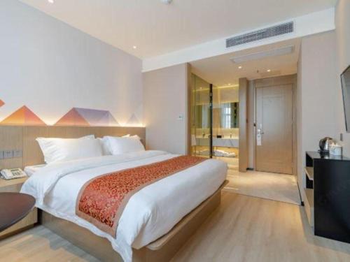 a bedroom with a large bed and a television at Borrman Hotel Hefei Yaohai Wanda Linquan East Road in Hefei