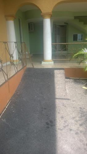 a porch of a building with a pillar and a balcony at Palm Bay Guest House & Restaurant in Montego Bay