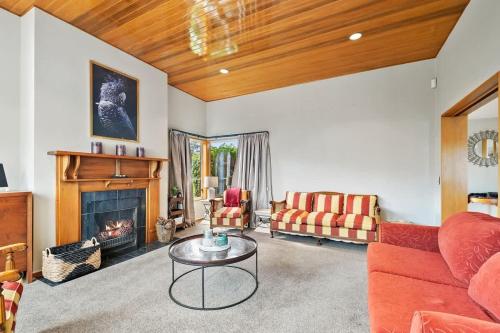 a living room with a couch and a fireplace at Lakeside Indulgence on Wilmot in Queenstown