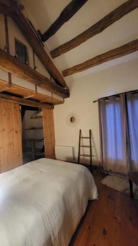 une chambre avec un lit blanc et une fenêtre dans l'établissement La Maison du chataignier, à Cassagnolles