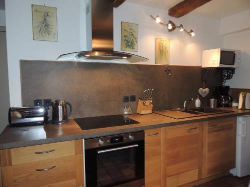 Saint-Montan的住宿－Le Mouleyras，厨房配有水槽和炉灶 顶部烤箱