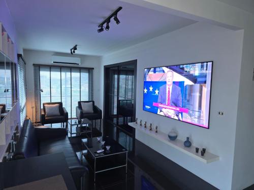 a living room with a flat screen tv on a wall at Flame Tree Suite 110 sqm 2-Bedroom Apartment in Hua Hin