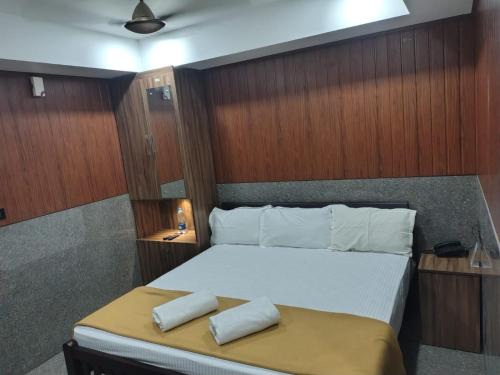a bedroom with a bed with two pillows on it at Lakshmi Residency Chottanikkara in Ernakulam