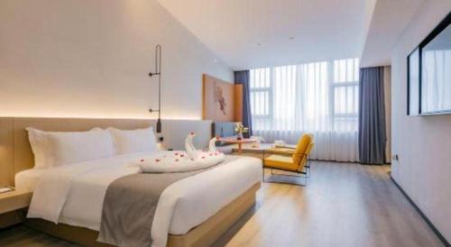 a hotel room with a large bed and a chair at Airfeel Hotel in Ziyang