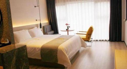 a hotel room with a large bed and a table at Airfeel Hotel in Ziyang