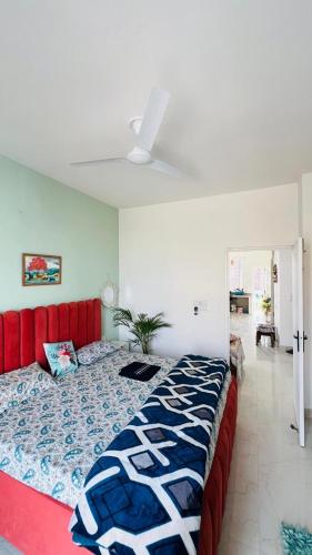 a bedroom with a large bed with a red headboard at Dhyani Residence in Nakraunda