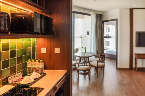 a kitchen and living room with a table in a room at Mandala Pearl Azure Retreat in Ấp Nhơn Long