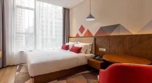 a hotel room with a bed and a table and a chair at Borrman Hotel Guilin Railway Station Two Rivers and Four Lakes in Guilin