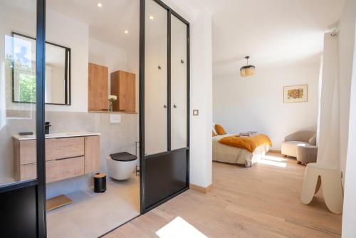 La salle de bains est pourvue d'une porte en verre menant à une chambre. dans l'établissement La Note Bleue Luberon, à Maubec