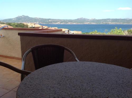 a table with a chair and a view of the ocean at Hotel Villa Gemella in Baja Sardinia