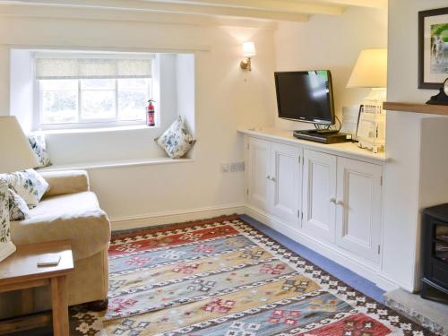 un salon avec un canapé et une télévision à écran plat dans l'établissement Swiss Cottage, à Rievaulx