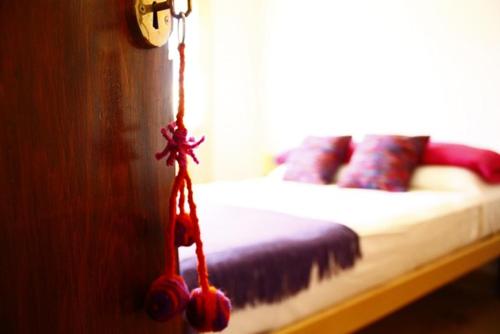 a bedroom with a bed with red pillows and a clock at Casa Suyay in Tilcara